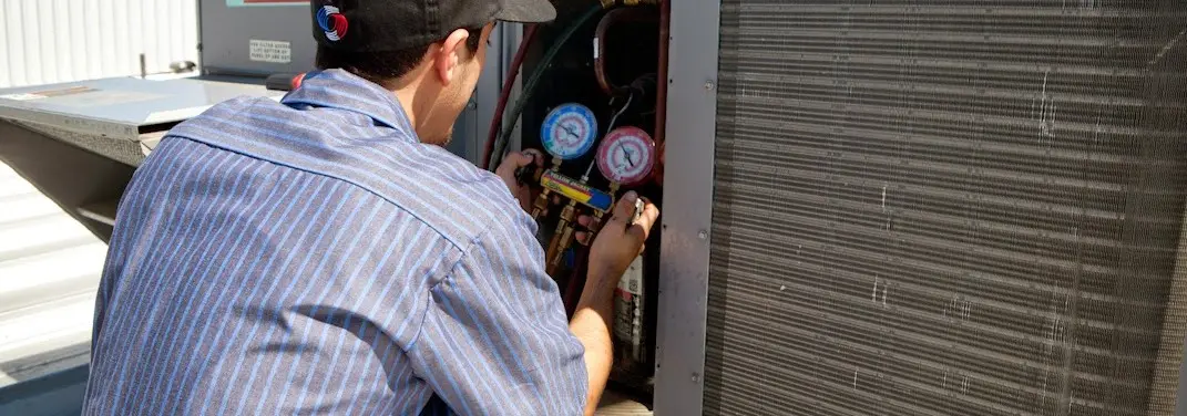 HVAC technician servicing a condenser unit in District Heights